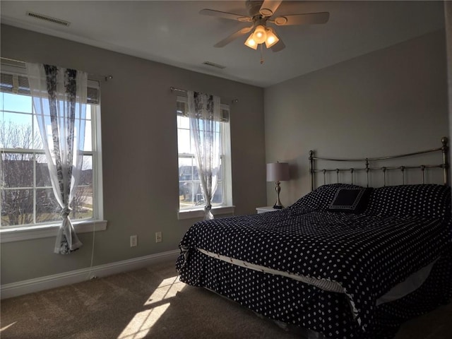 carpeted bedroom with visible vents, a ceiling fan, and baseboards