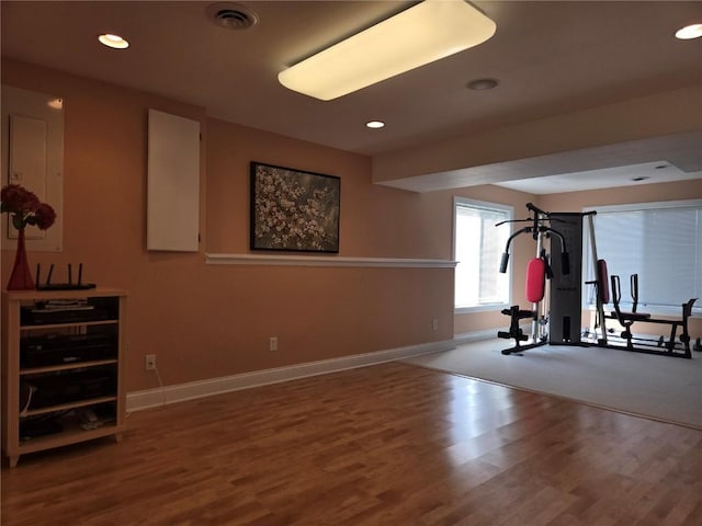 exercise room featuring visible vents, recessed lighting, baseboards, and wood finished floors