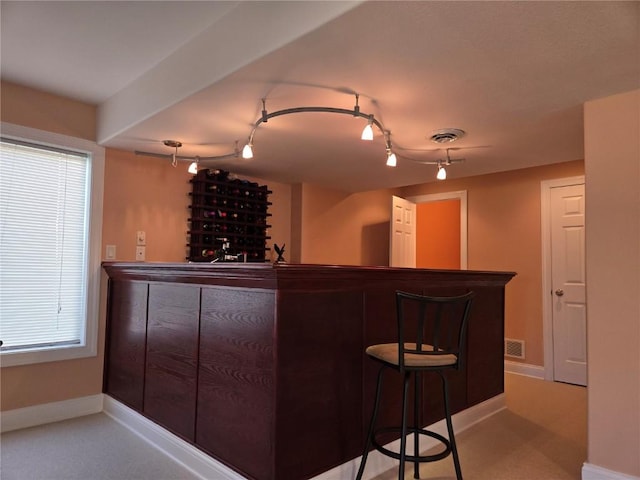 bar with a dry bar, baseboards, and visible vents