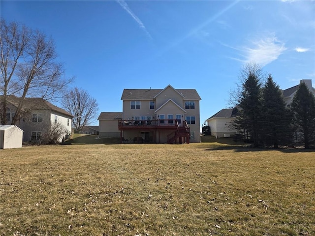 back of property with a deck, stairway, and a yard