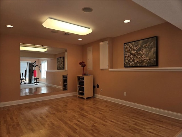 workout room with recessed lighting, baseboards, and wood finished floors