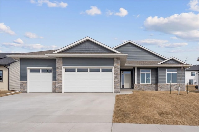 view of front of home with a garage, stone siding, driveway, and roof with shingles