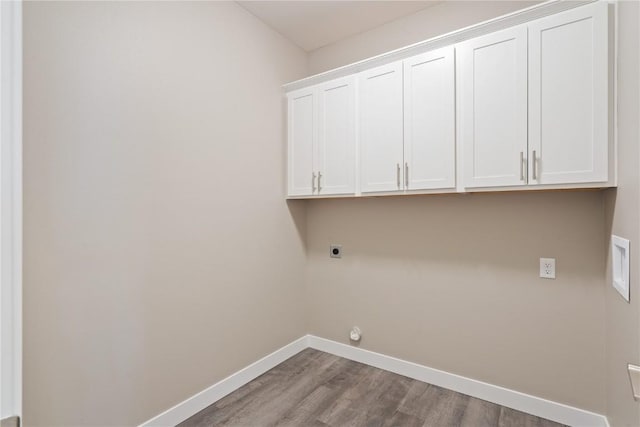 washroom with wood finished floors, cabinet space, baseboards, and hookup for an electric dryer