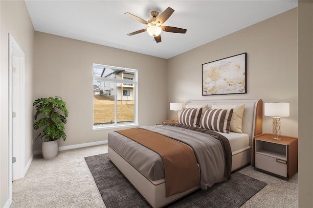 bedroom with a ceiling fan, baseboards, and light carpet