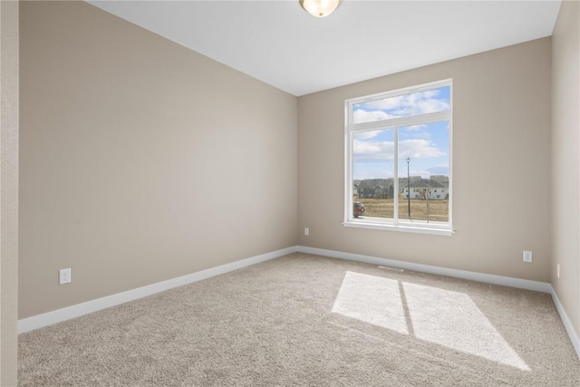 carpeted spare room featuring baseboards