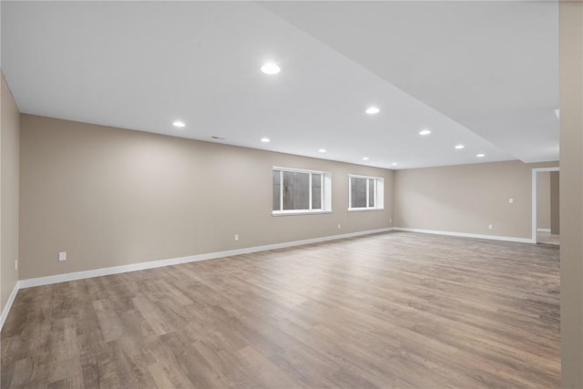 empty room featuring baseboards and light wood-type flooring