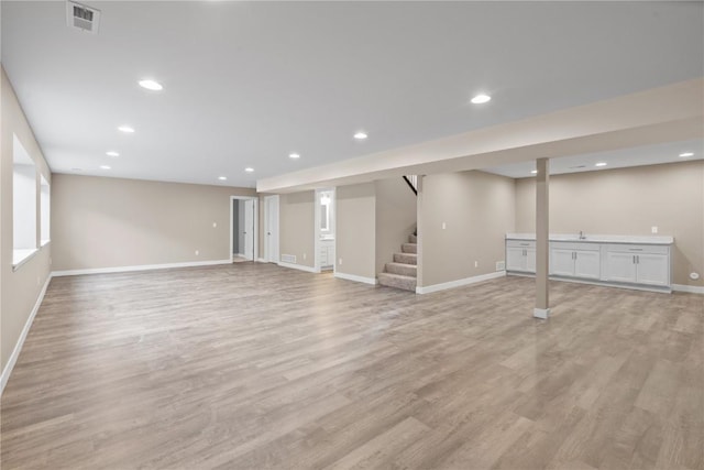 basement with stairway, recessed lighting, visible vents, and light wood finished floors