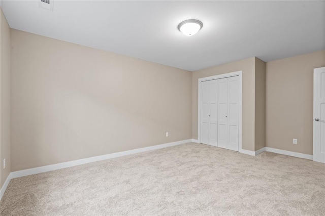 unfurnished bedroom featuring a closet, carpet flooring, visible vents, and baseboards