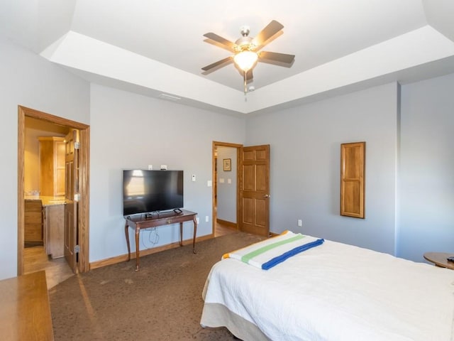 bedroom featuring a tray ceiling, a ceiling fan, and baseboards