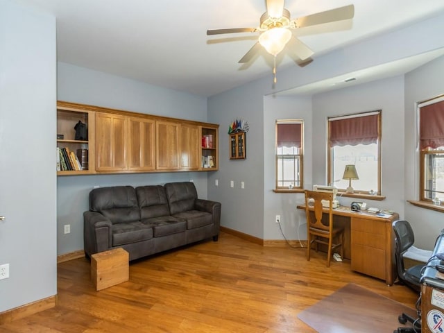 office space with light wood-style flooring, baseboards, and a ceiling fan