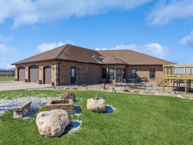 rear view of house with a garage, brick siding, driveway, and a lawn