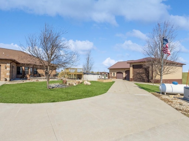 view of front of home featuring a front lawn, an attached garage, driveway, and stucco siding