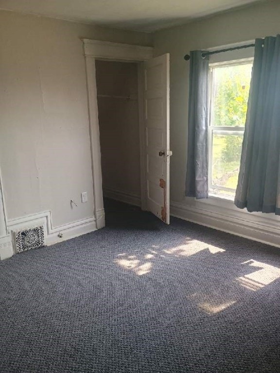 unfurnished bedroom with carpet floors, baseboards, and a closet