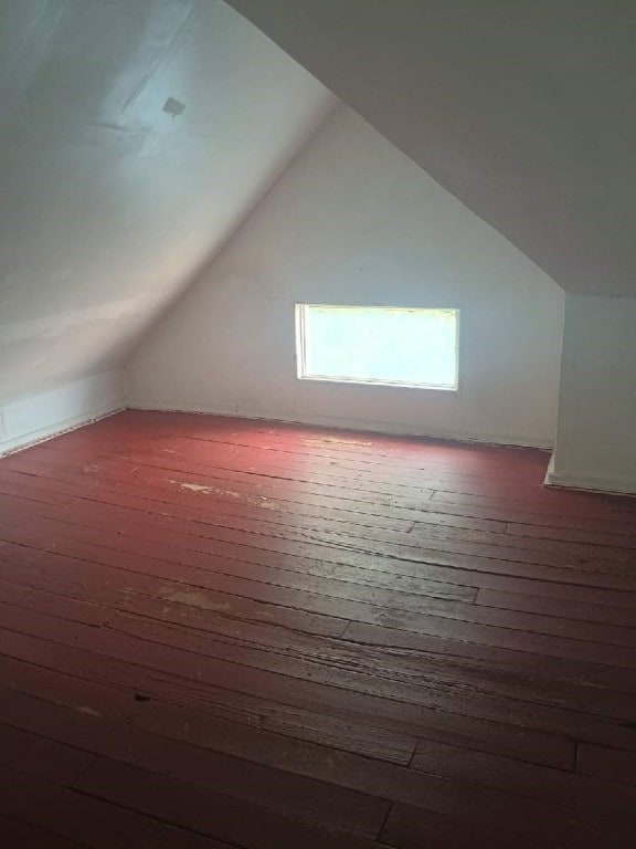 bonus room with wood-type flooring and vaulted ceiling