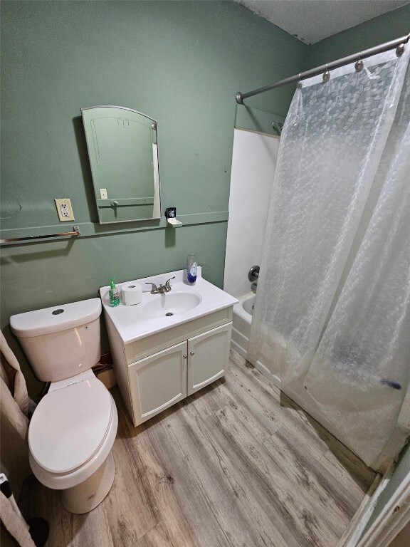 1416/1418 3rd Ave SE, Cedar Rapids, IA 52403 - full bathroom with wood finished floors, vanity, toilet, and shower / tub combo with curtain