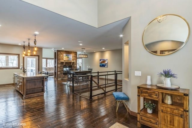 dining space with dark wood-style floors, recessed lighting, a fireplace, and baseboards