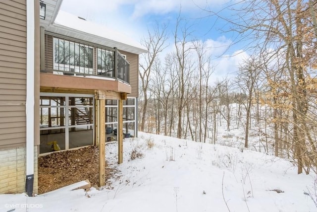 yard covered in snow featuring a balcony