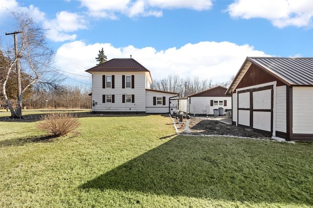 back of property with a garage, a lawn, and an outdoor structure