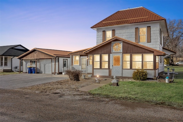 view of front of home featuring concrete driveway, a garage, and metal roof