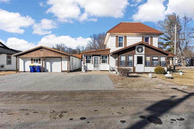 view of front of home with aphalt driveway and a garage