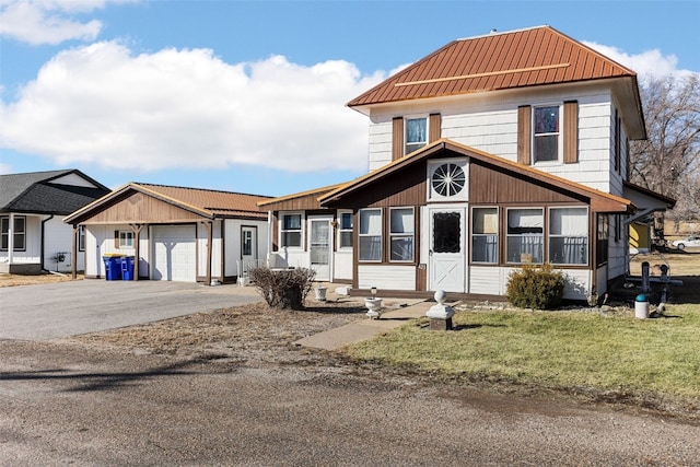 view of front of home featuring a garage, driveway, and metal roof