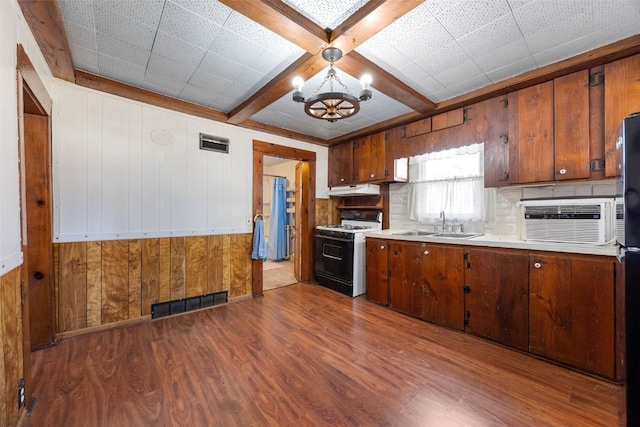 kitchen with a notable chandelier, range with gas stovetop, visible vents, and dark wood-style flooring