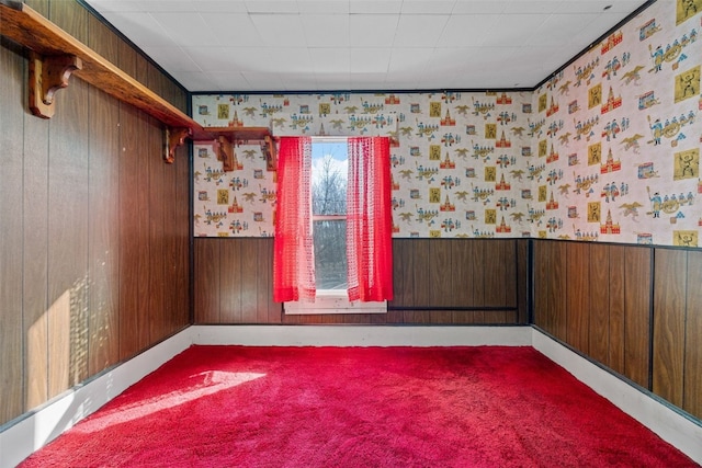 empty room with a wainscoted wall, carpet flooring, wallpapered walls, and wood walls