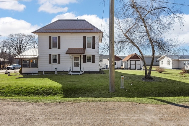 view of front of property with metal roof, entry steps, a front lawn, and a standing seam roof