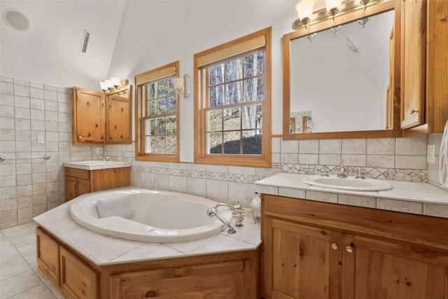 3098 Sandy Beach Rd NE, Solon, IA 52333 - bathroom with two vanities, a sink, tile patterned flooring, lofted ceiling, and a bath