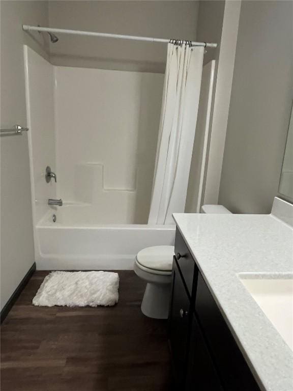full bathroom featuring toilet, wood finished floors, shower / tub combo, vanity, and baseboards