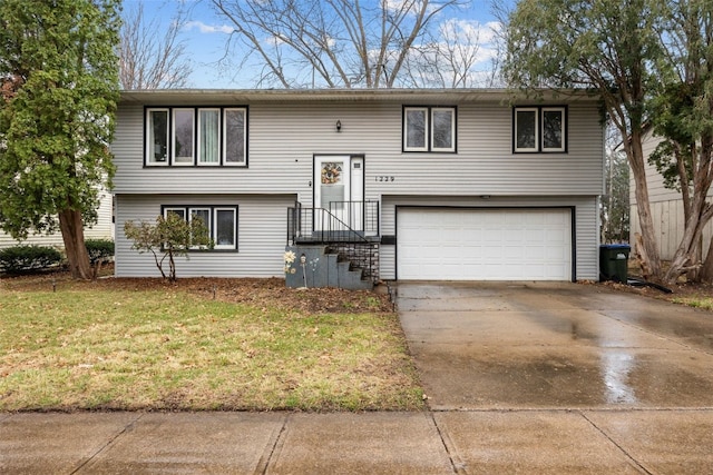 bi-level home with a garage, concrete driveway, and a front yard