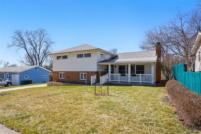 view of front of house featuring a front yard, fence, covered porch, a chimney, and brick siding