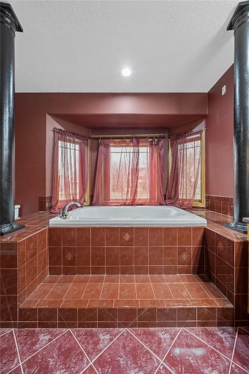 7012 Deer Horn Trl NE, Cedar Rapids, IA 52411 - bathroom featuring a garden tub, tile patterned floors, and a wood stove