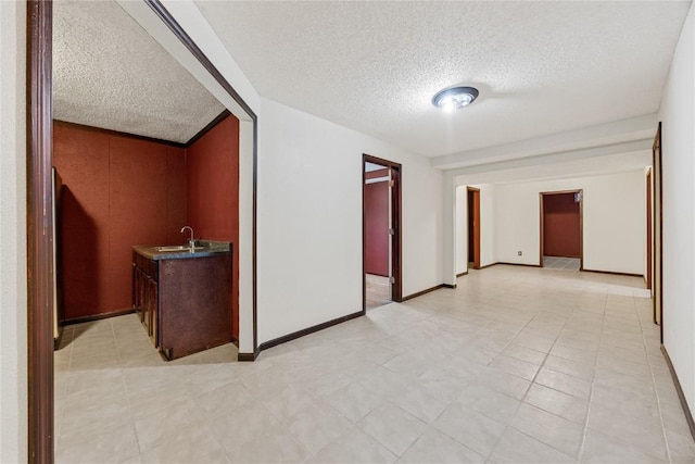 7012 Deer Horn Trl NE, Cedar Rapids, IA 52411 - spare room with a textured ceiling, a sink, and baseboards