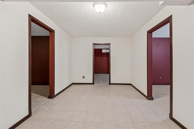 7012 Deer Horn Trl NE, Cedar Rapids, IA 52411 - unfurnished room with a textured ceiling, baseboards, and light tile patterned floors