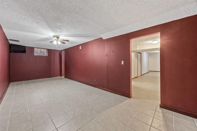 7012 Deer Horn Trl NE, Cedar Rapids, IA 52411 - unfurnished room with a textured ceiling, light tile patterned floors, ceiling fan, and baseboards