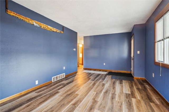 206 E Jackson St, Grandview, IA 52752 - unfurnished room with wood finished floors, visible vents, and baseboards