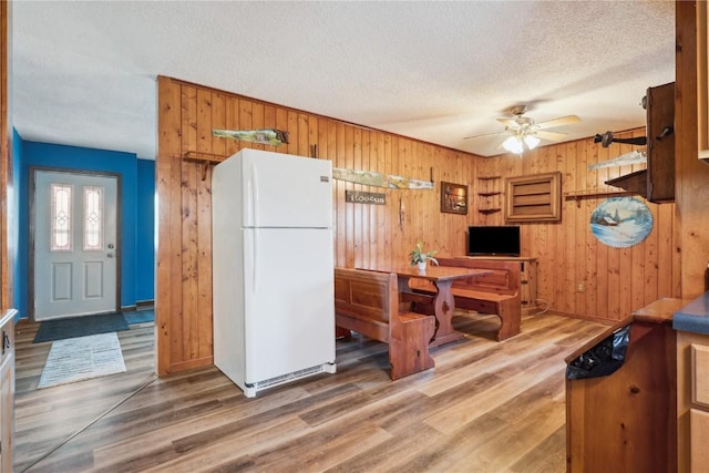 206 E Jackson St, Grandview, IA 52752 - dining room with wooden walls, a textured ceiling, ceiling fan, and wood finished floors