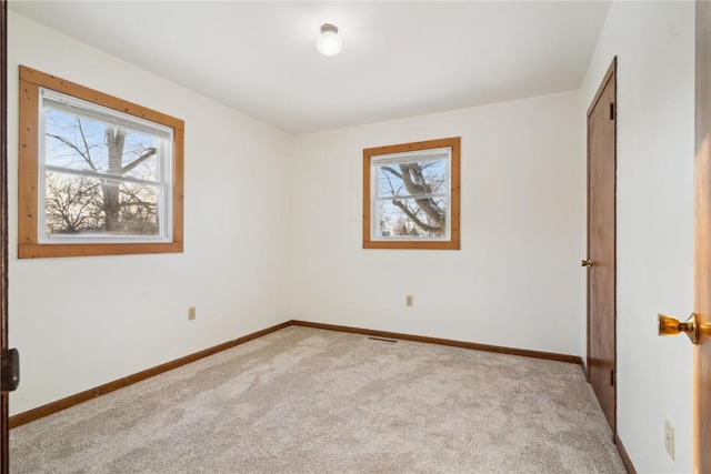 206 E Jackson St, Grandview, IA 52752 - unfurnished bedroom featuring baseboards, multiple windows, and carpet floors