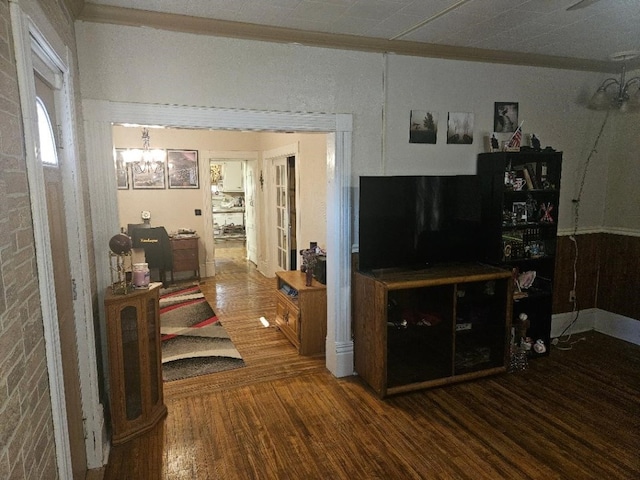 1502 9th Ave, Belle Plaine, IA 52208 - living room featuring a chandelier, wood finished floors, and ornamental molding
