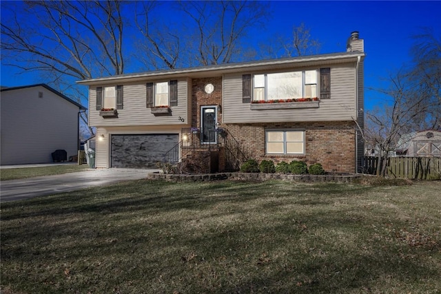 bi-level home with brick siding, a front yard, driveway, and a garage