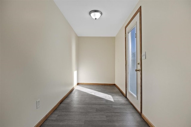 corridor featuring baseboards and wood finished floors