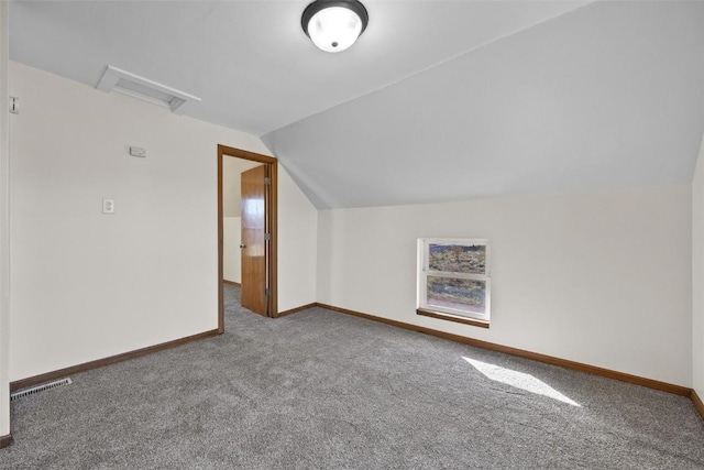 additional living space with carpet floors, attic access, lofted ceiling, baseboards, and visible vents