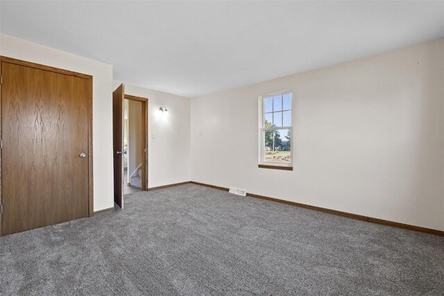 unfurnished bedroom featuring carpet flooring, a closet, baseboards, and visible vents