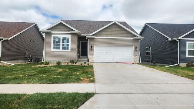 9124 Grand Oaks Dr NE, Cedar Rapids, IA 52402 - view of front of home featuring a garage, driveway, a front lawn, and stone siding