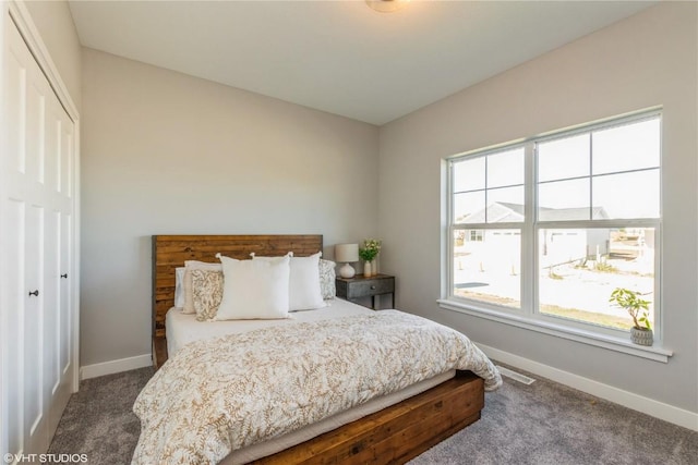 bedroom with a closet, visible vents, baseboards, and carpet floors