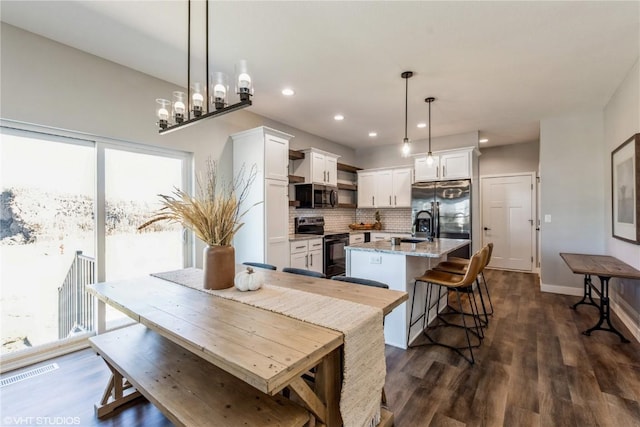 dining space with recessed lighting, dark wood-type flooring, visible vents, and baseboards