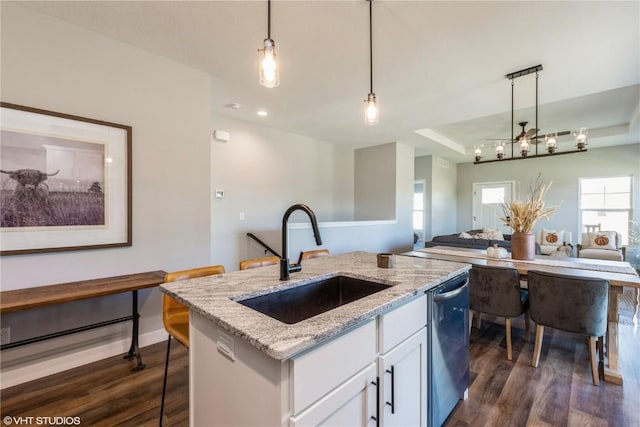 kitchen featuring stainless steel dishwasher, open floor plan, dark wood-style flooring, and a sink