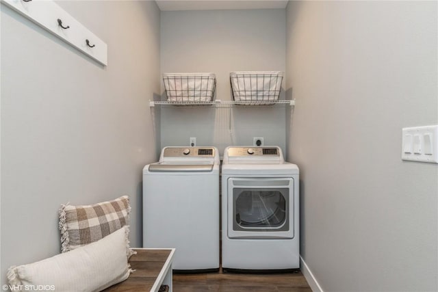 washroom featuring dark wood-style flooring, washing machine and clothes dryer, and laundry area