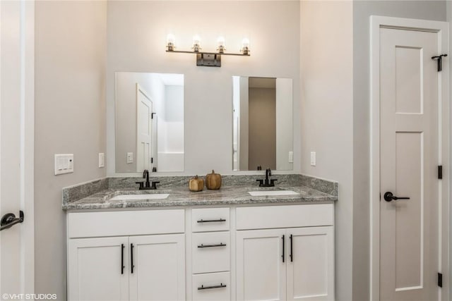 bathroom with a sink and double vanity